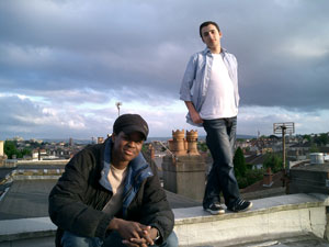 two men looking at the sunset beyond the camera